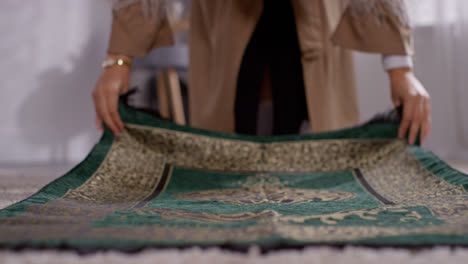 Nahaufnahme-Einer-Muslimischen-Frau-Zu-Hause,-Die-Einen-Gebetsteppich-Auf-Etage-1-Ablegt